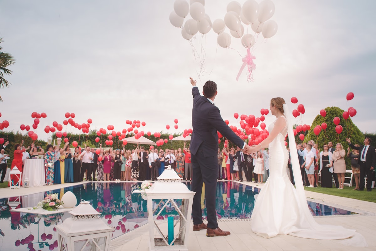 Newlyweds releasing balloons at an outdoor reception