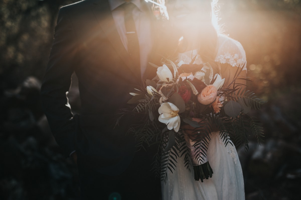 Bride and groom at golden hour holding a bouquet